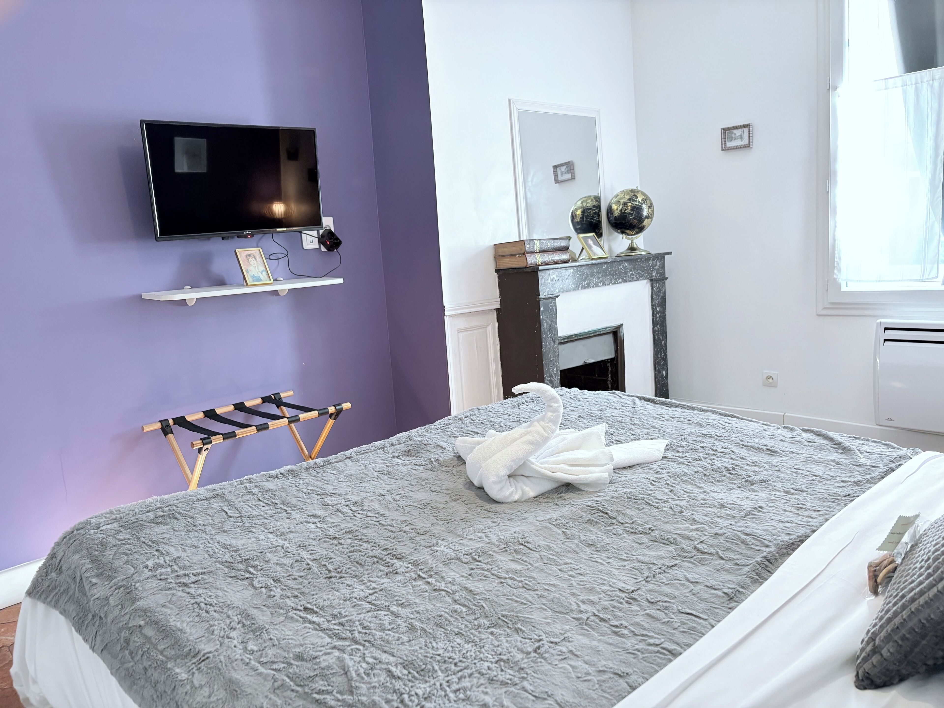 Une chambre d’hôtel avec un lit, une télévision, une cheminée et une fenêtre.