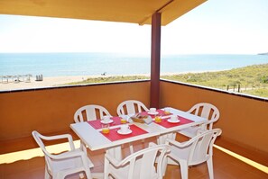 A balcony with a table set for breakfast, overlooking a beach and the sea. - Apartamentos Beach & Golf Resort (Pals)