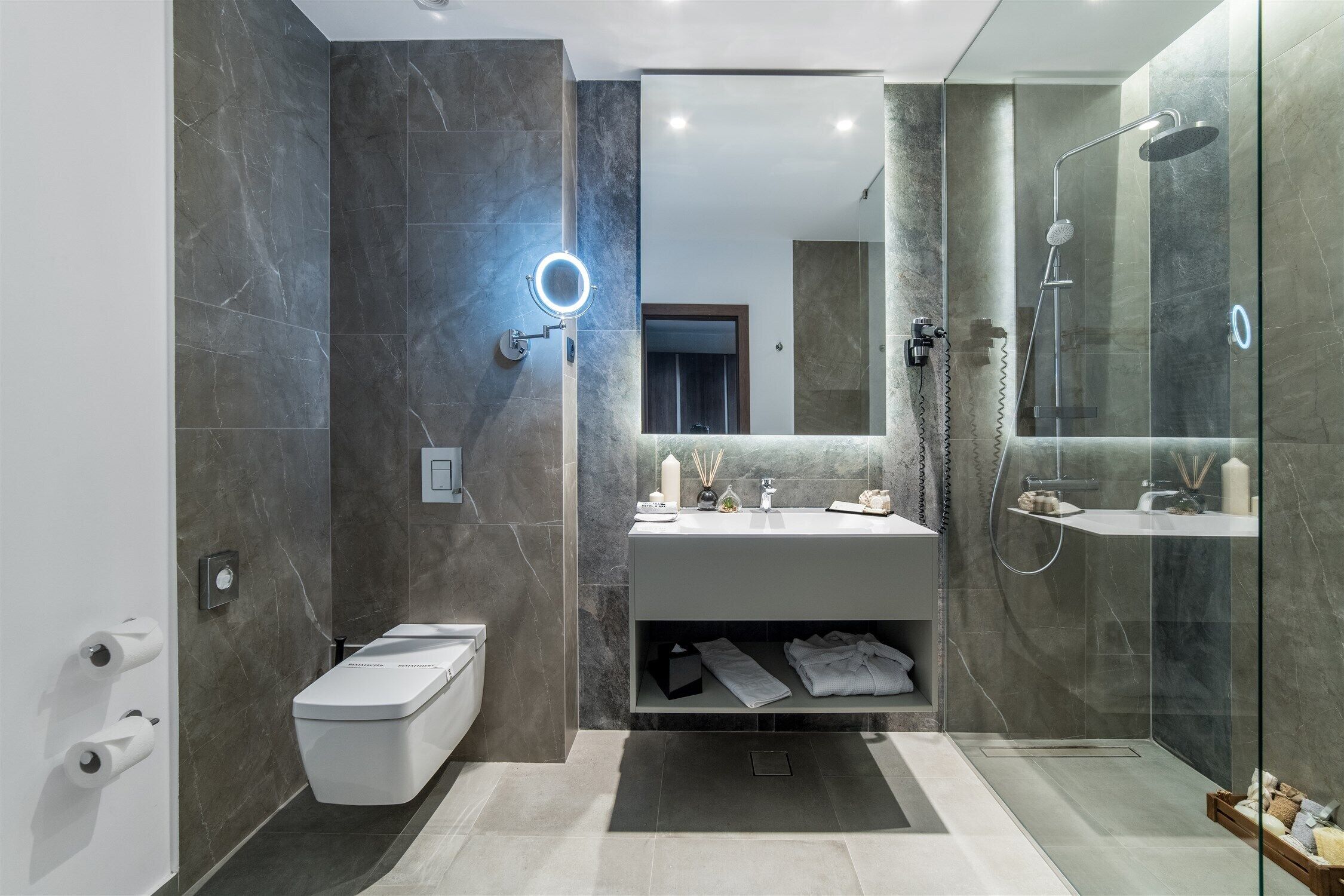 Un baño moderno con inodoro, tocador y ducha.