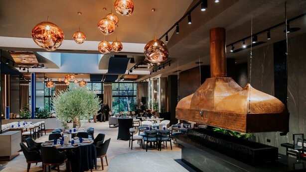 A modern dining area with round tables, chairs, and hanging spherical light fixtures. - Sky Blue Hotel & Spa (Paulestii Noi)