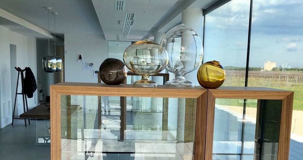 Un interior moderno con una mesa de madera que exhibe objetos de vidrio decorativos.