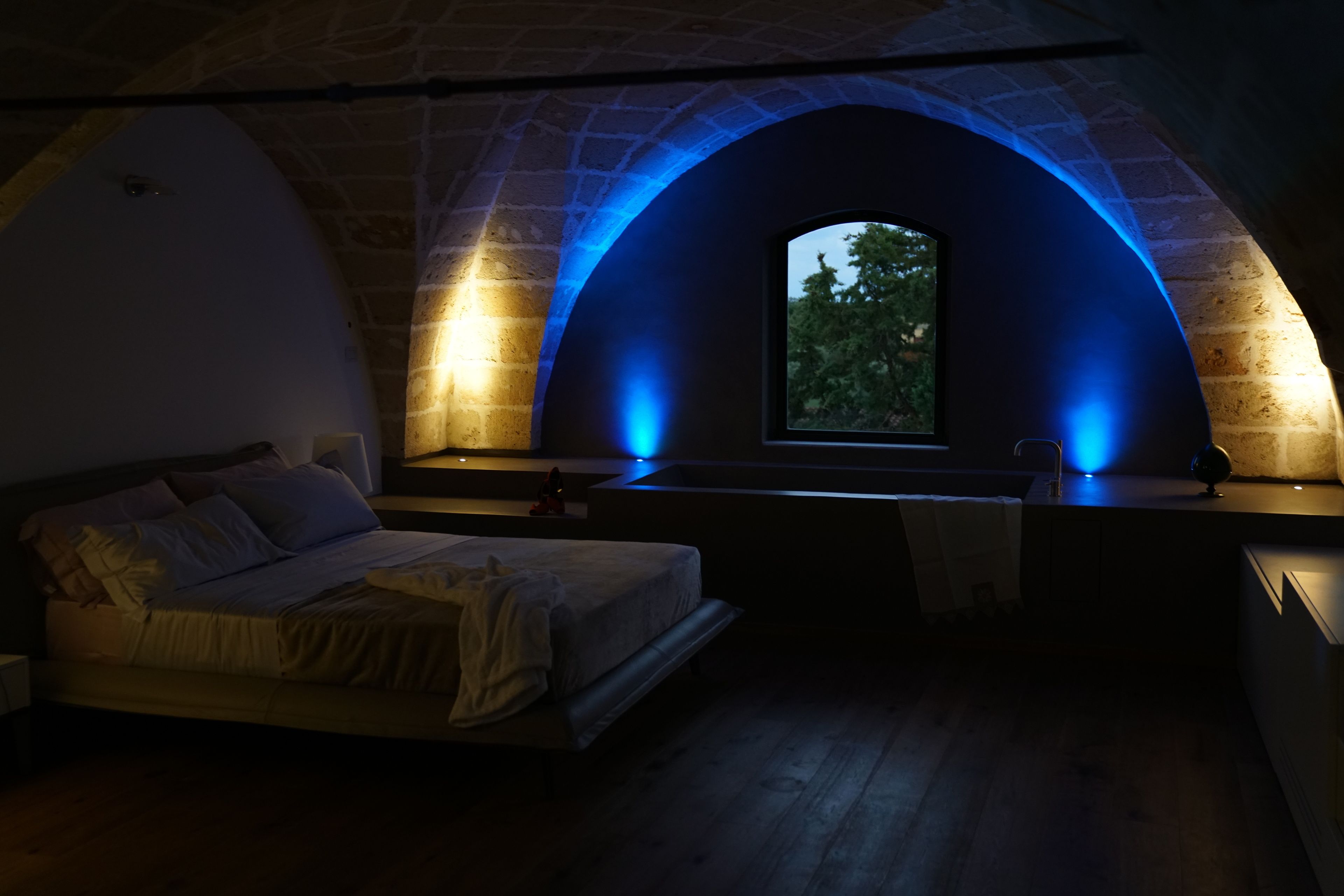 Quarto com arco de pedra e janela.