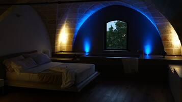 Quarto com arco de pedra e janela.