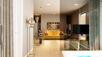 Una sala moderna con un sofá amarillo, una mesa de centro de vidrio y un televisor de pantalla plana.