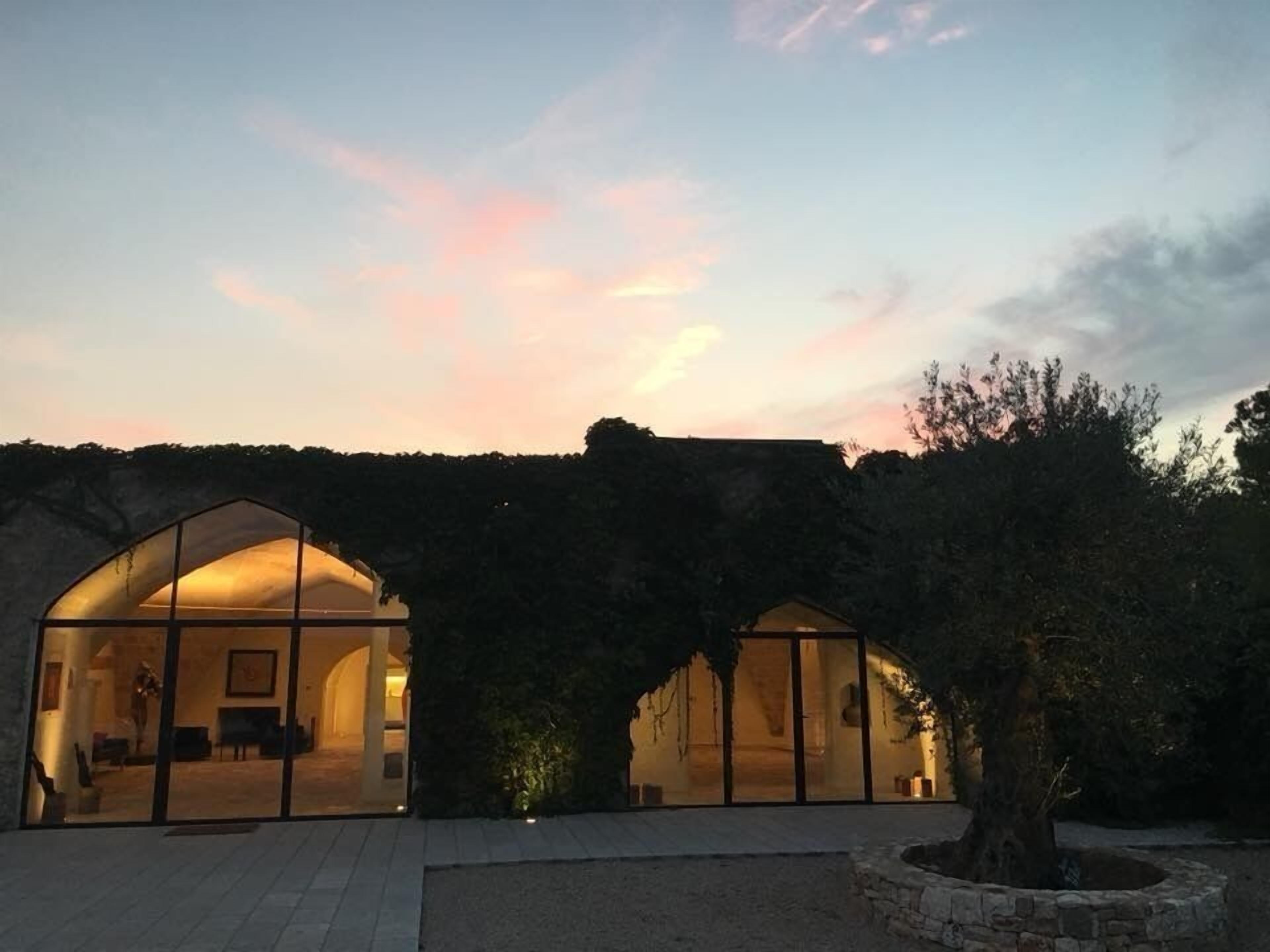 Un edificio moderno con puertas de vidrio arqueadas y una pared de piedra al fondo.