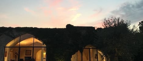 Un edificio moderno con puertas de vidrio arqueadas y una pared de piedra al fondo.