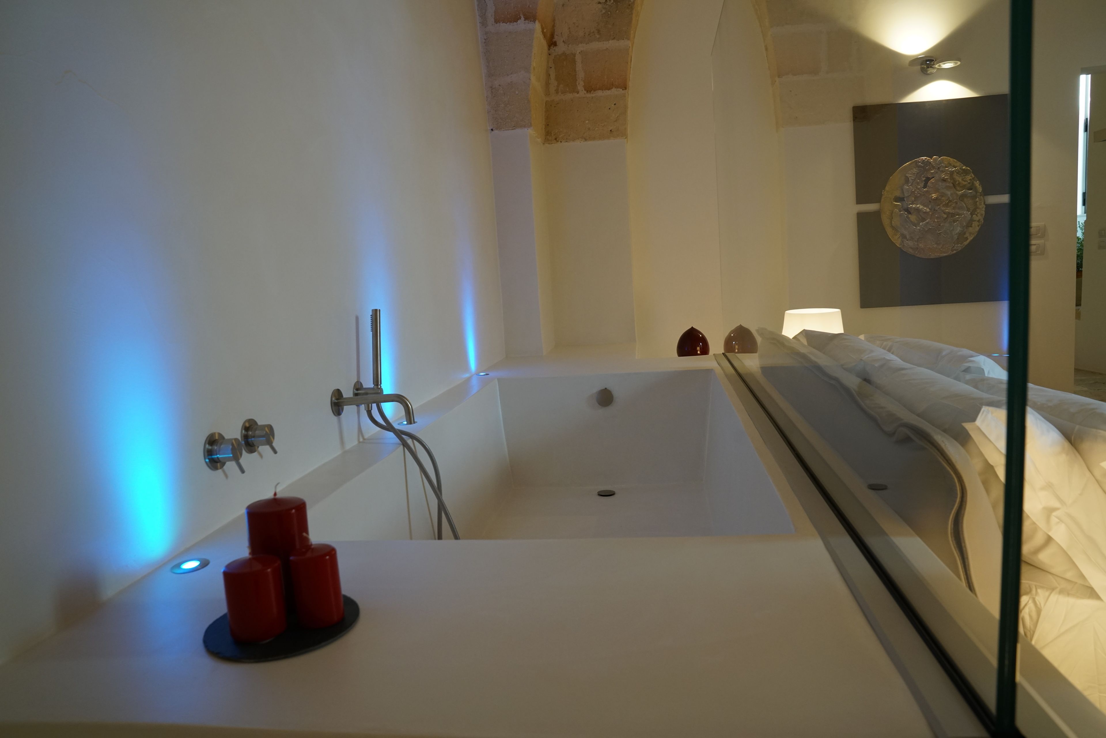 Une salle de bain moderne avec une baignoire, un miroir et un lavabo.