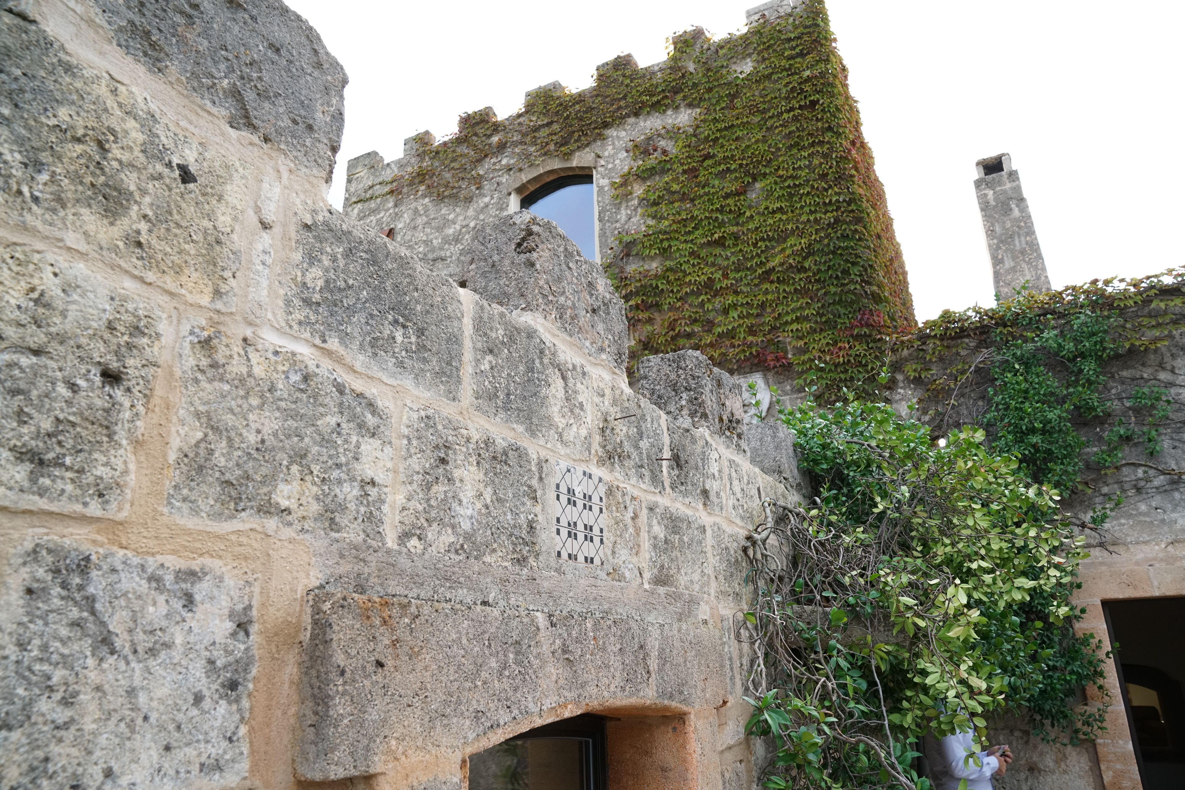 A stone building with a window and an archway.