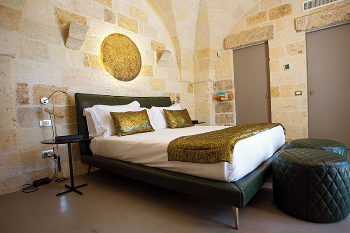 Ein Schlafzimmer mit einem Bett, einem Nachttisch und einer Wandleuchte.