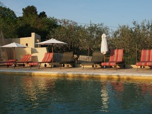 Utendørsbasseng,et oppvarmet basseng, bassengparasoller og solsenger