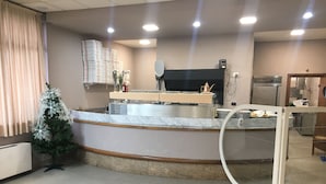 A reception area with a marble counter, a Christmas tree, and a glass partition. - Il Calipso by Mago (Turbigo)