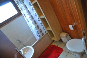 Un baño con ducha, inodoro y lavabo.