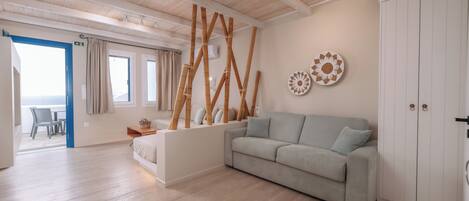 Una sala moderna con un sofá de color claro, un panel de madera y un armario blanco.