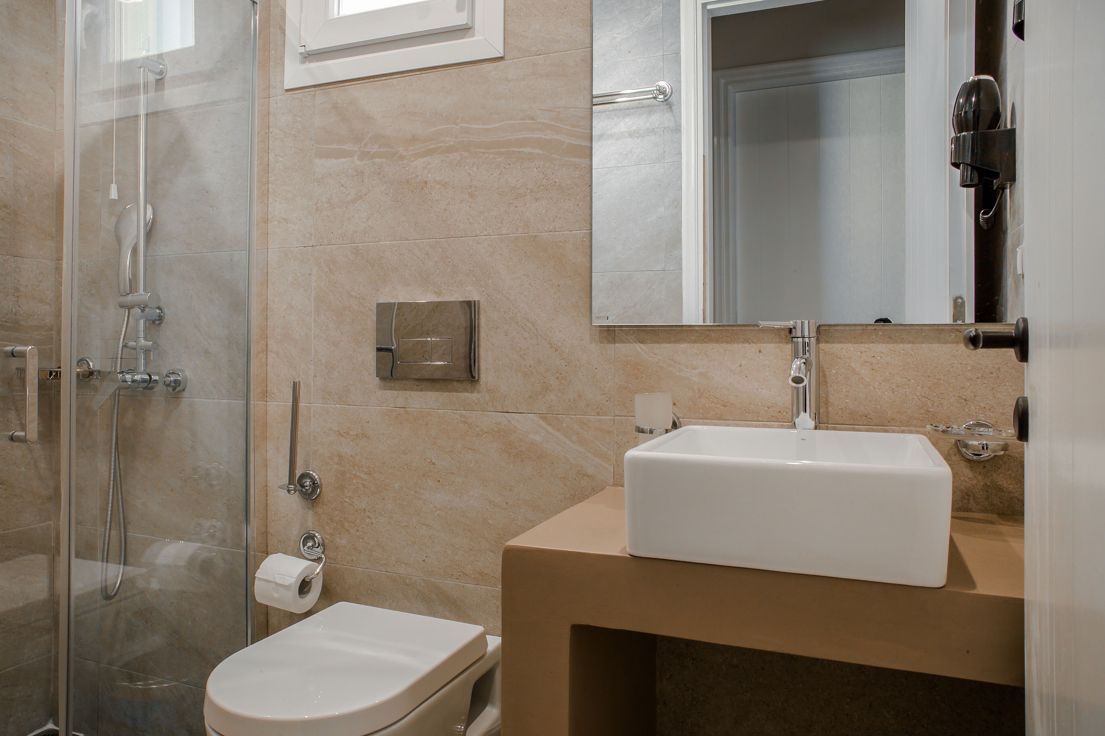 Un baño con ducha acristalada, inodoro, lavabo y espejo.