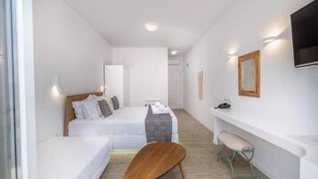 Ein Schlafzimmer mit zwei Betten, einer Holzbank, einem kleinen Hocker, einem Fernseher und einem Spiegel.