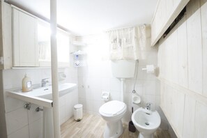 A bathroom with a toilet, bidet, sink, and mirror. - La cutizza (Martina Franca)