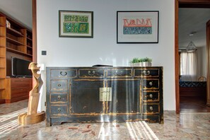 Una habitación con un mueble de madera grande, un televisor y cuadros en la pared.