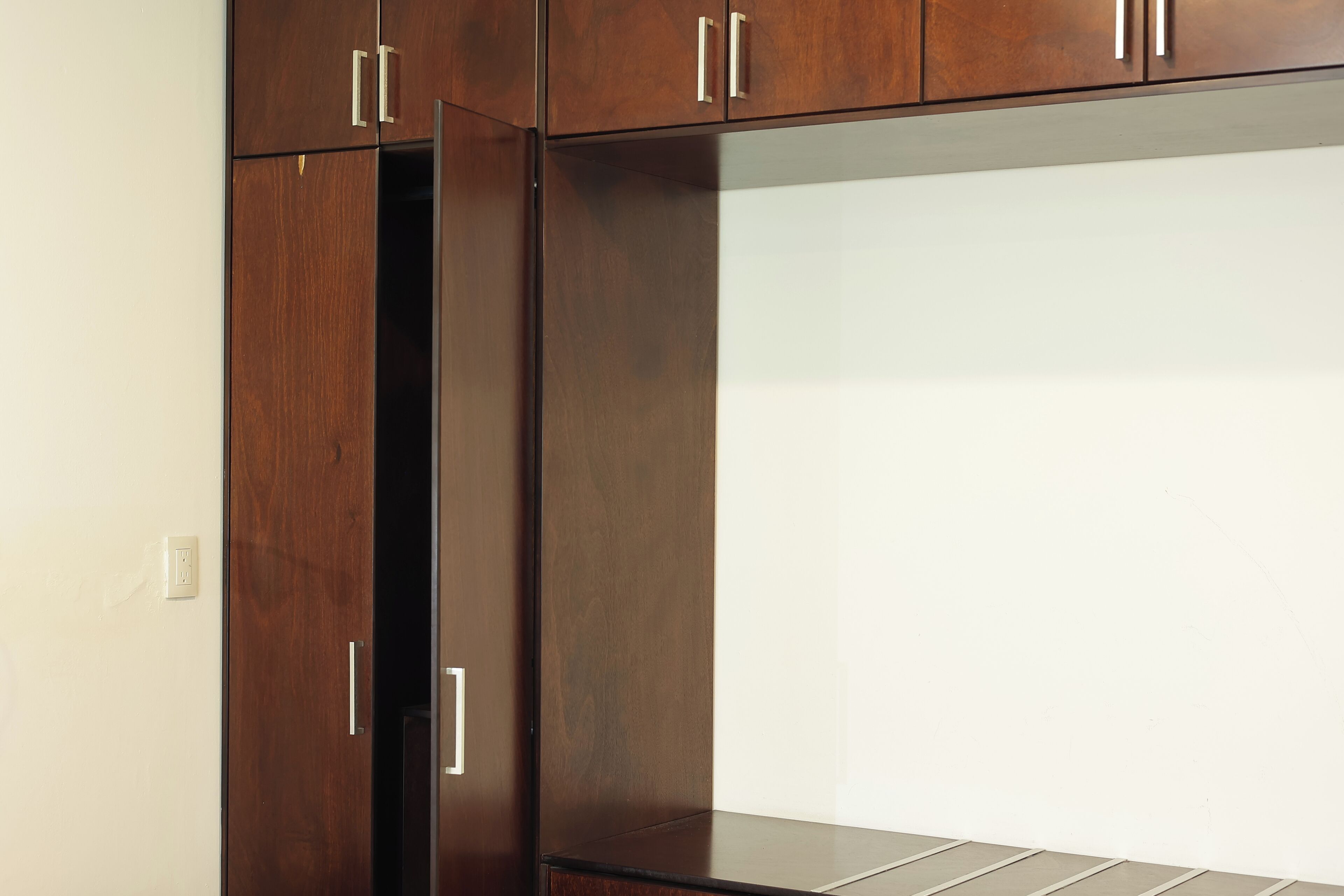 A wooden wardrobe with two doors and a mirrored section.