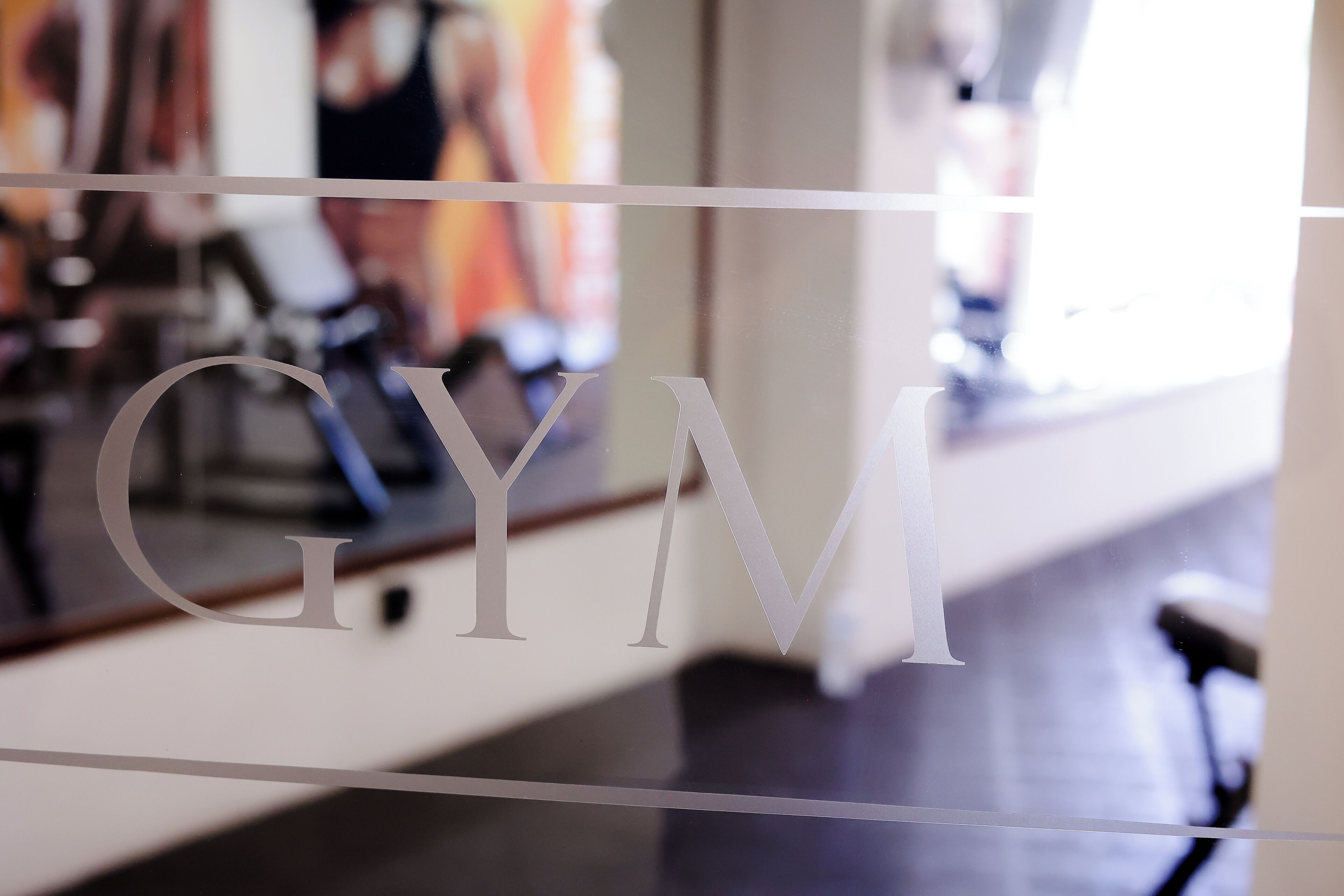Un gimnasio con pared espejada y equipamiento de ejercicio.