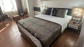 A hotel room with a large bed, bedside tables, a chair, and a desk. - Grand Ari Hotel (Afyonkarahisar)