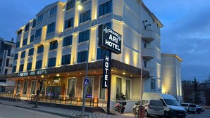 A multi-story hotel with a prominent sign, a covered entrance, and a parking area. - Grand Ari Hotel (Afyonkarahisar)
