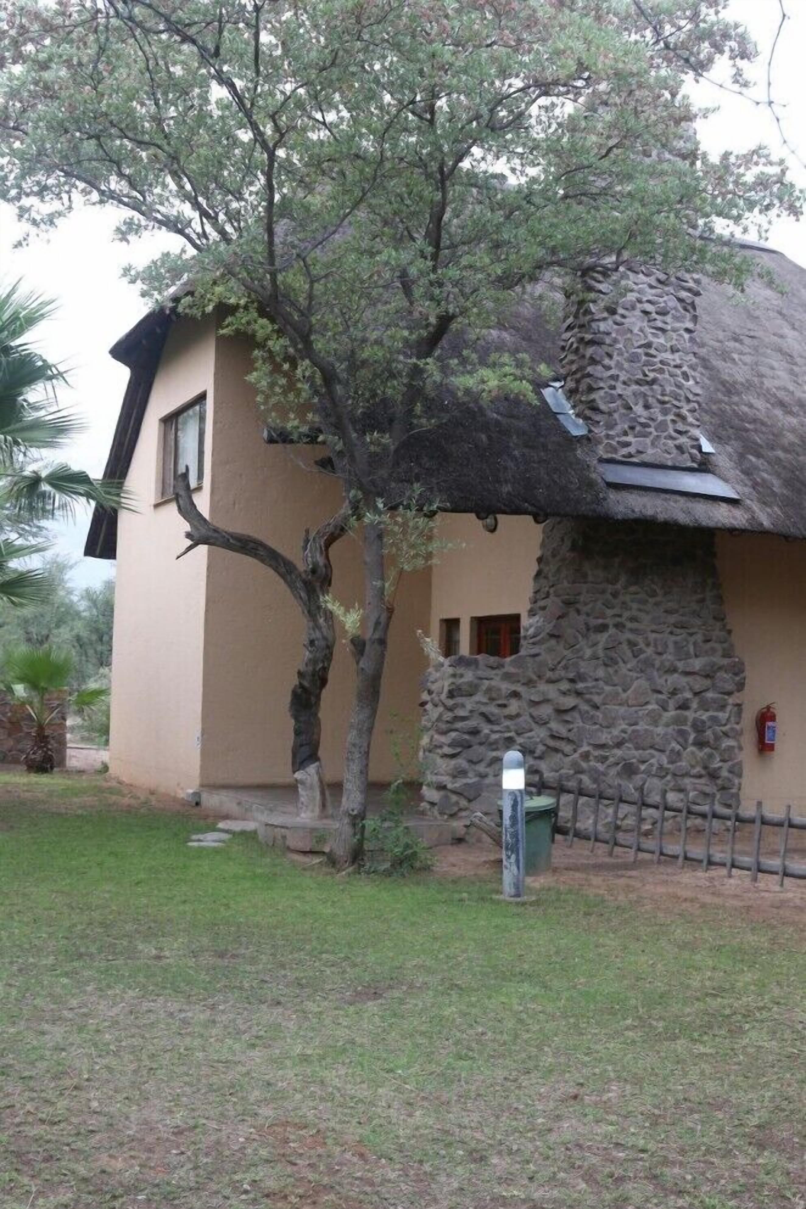 A building with a stone exterior and a thatched roof.