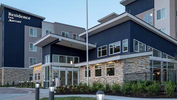 A modern hotel with a stone facade, large windows, and a prominent entrance.