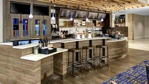 Un área de bar moderna con techo de madera, taburetes y una barra con un tablero de menú.