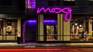 A building with a neon sign reading "mozy" and a modern interior visible through the windows. - MOXY Minneapolis Uptown (Minneapolis)