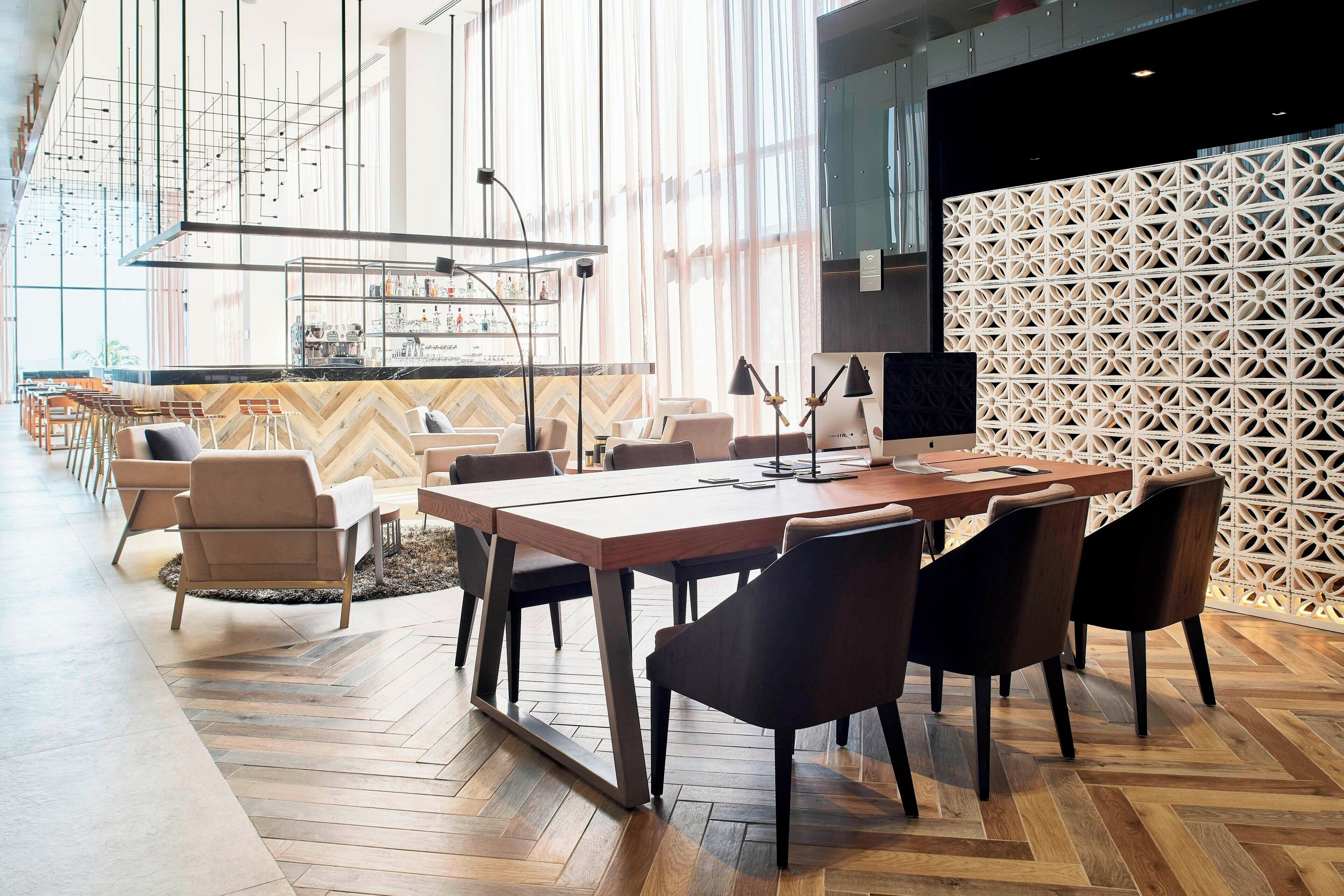 Une salle de conférence moderne, dotée d’une grande table, de chaises et d’un espace bar.