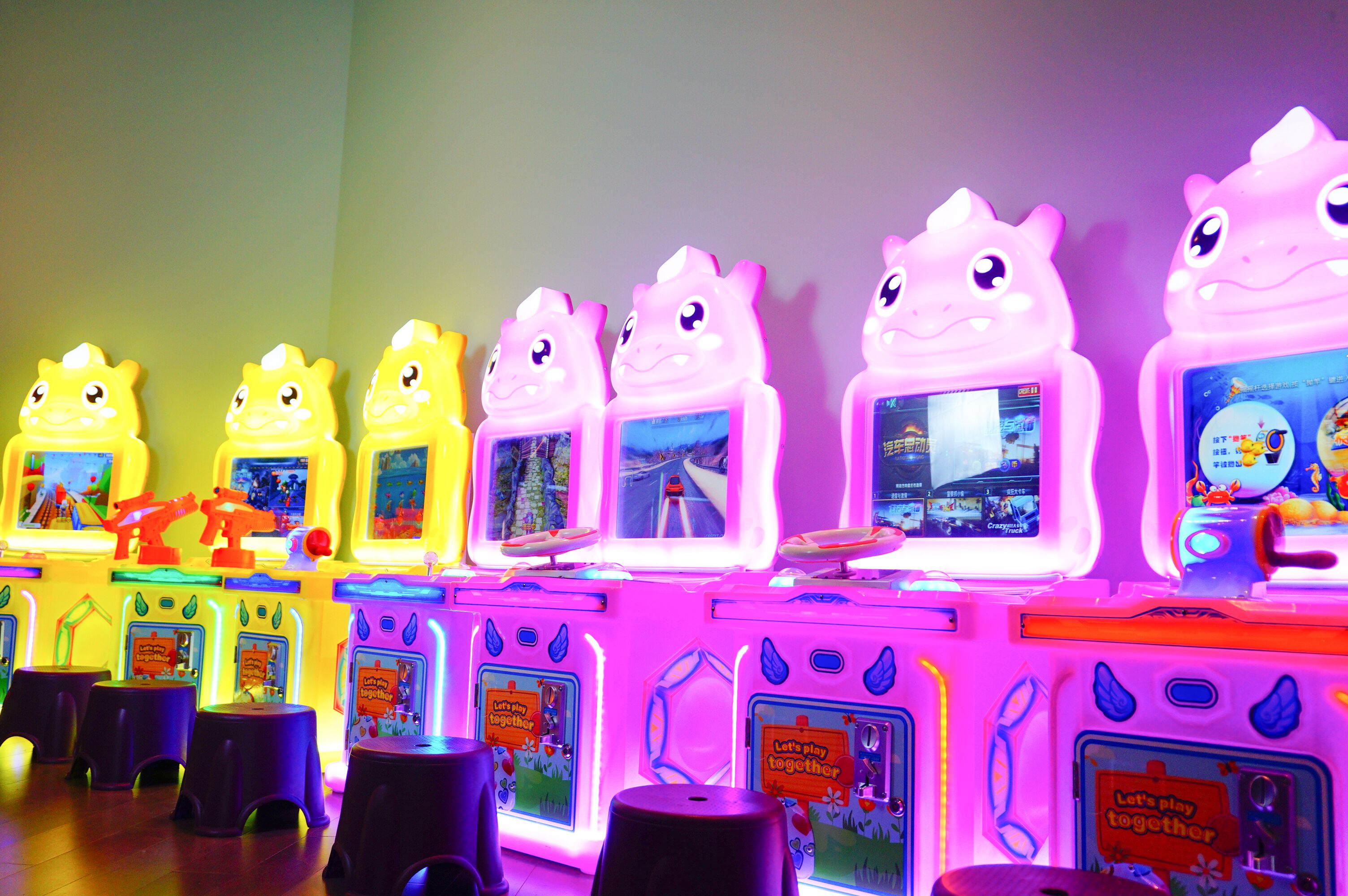 Una hilera de máquinas de arcade iluminadas con pantallas, cada una mostrando un juego diferente.