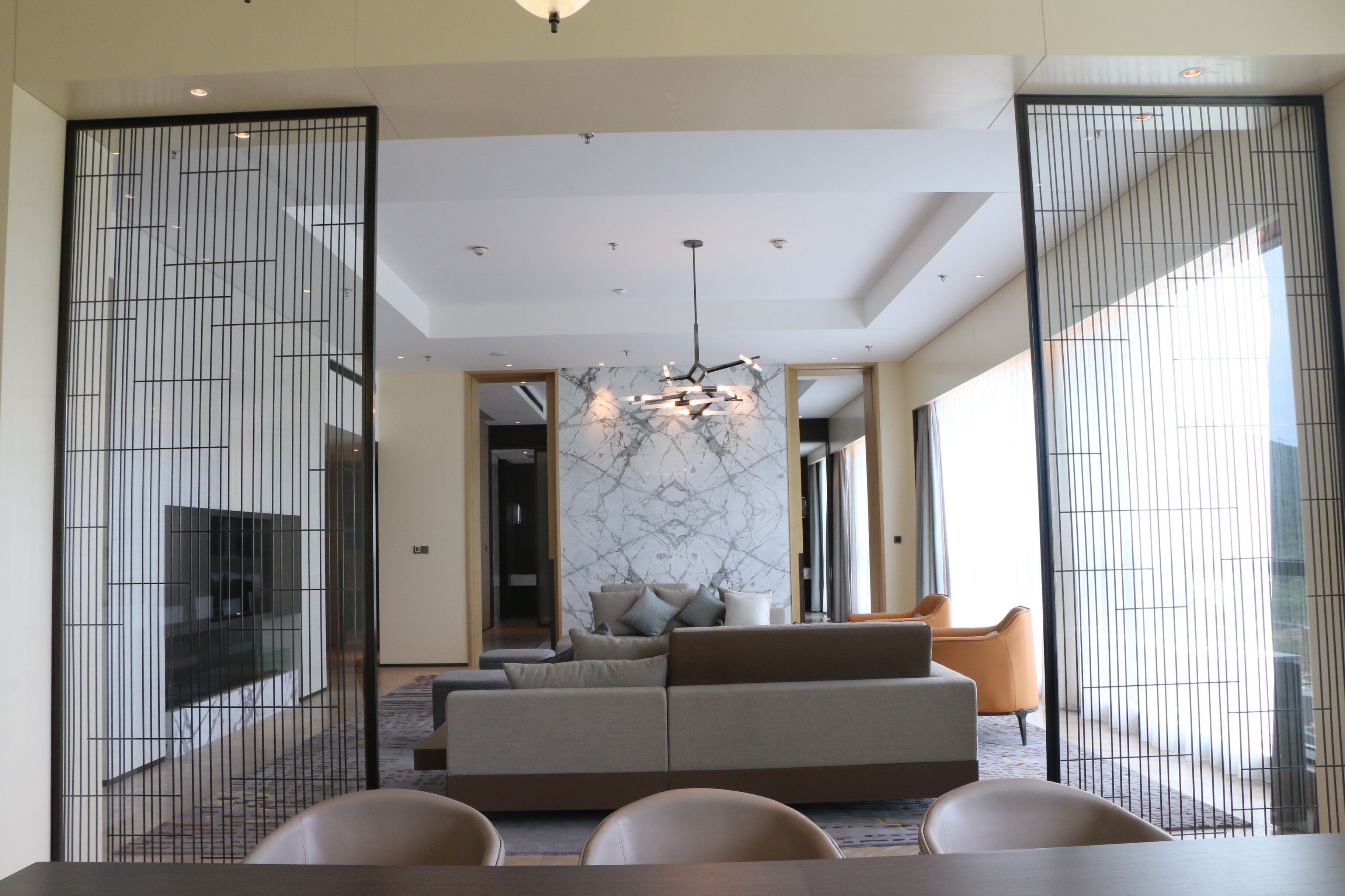 A modern living room with a sofa, chairs, and a dining table.