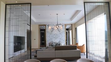 A modern living room with a sofa, chairs, and a dining table.
