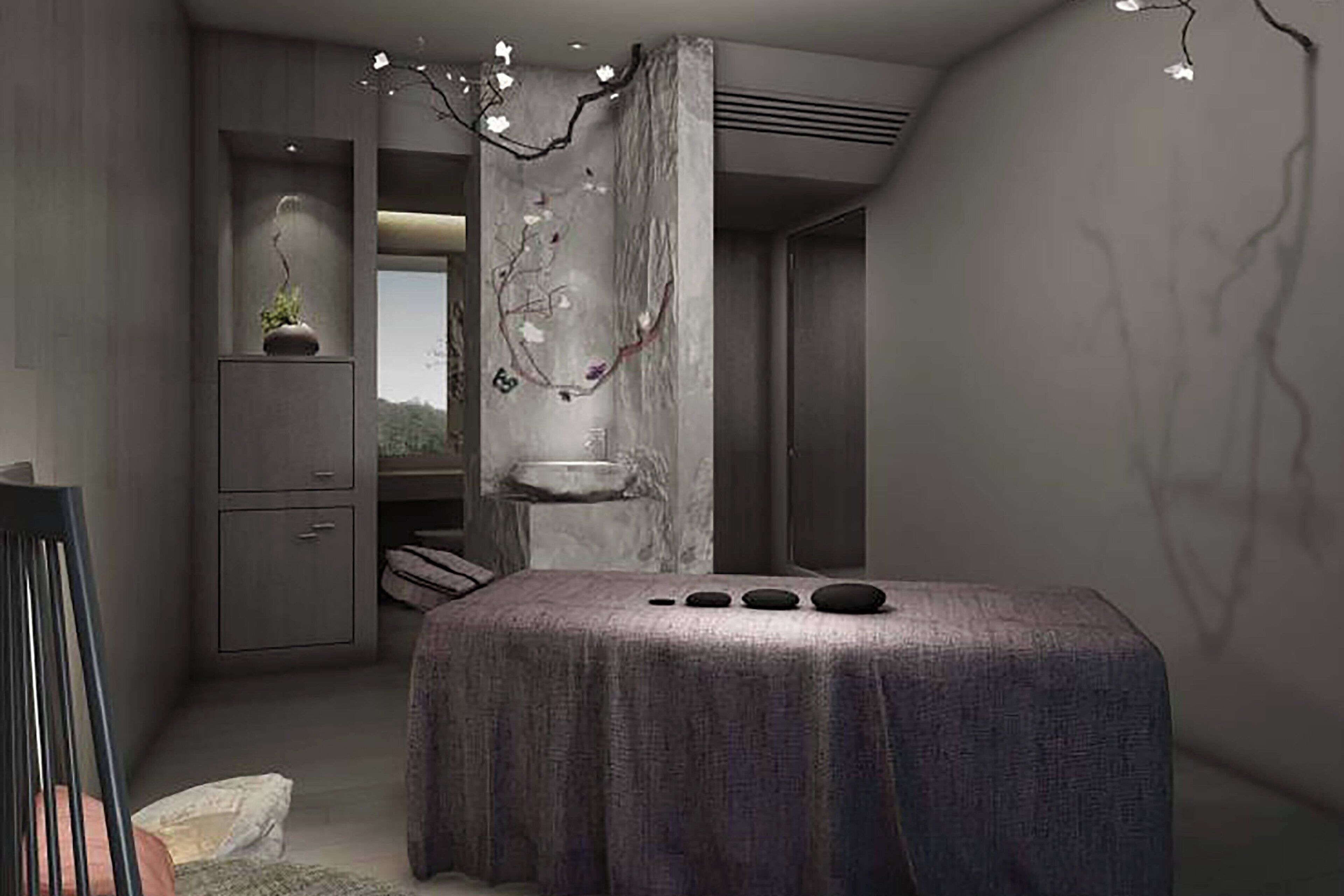 Une pièce moderne équipée d’une table de massage, d’un petit meuble et d’un élément décoratif mural.