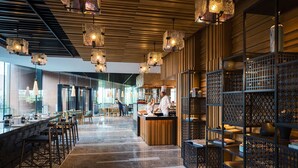 A modern restaurant interior with wooden paneling, hanging pendant lights, and a central counter. - Renaissance Suzhou Taihu Lake Hotel (Suzhou)