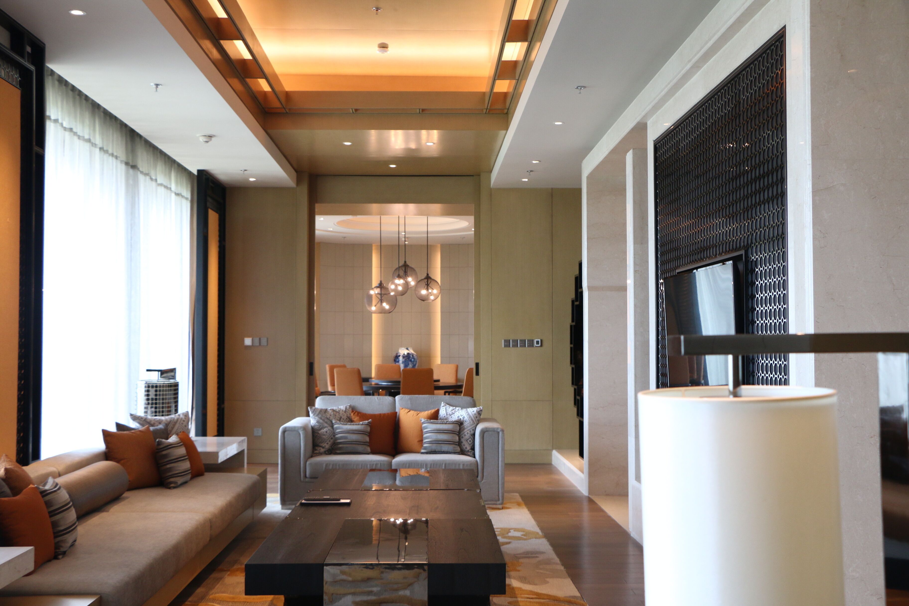 A spacious living area with a sofa set, a coffee table, and a TV.