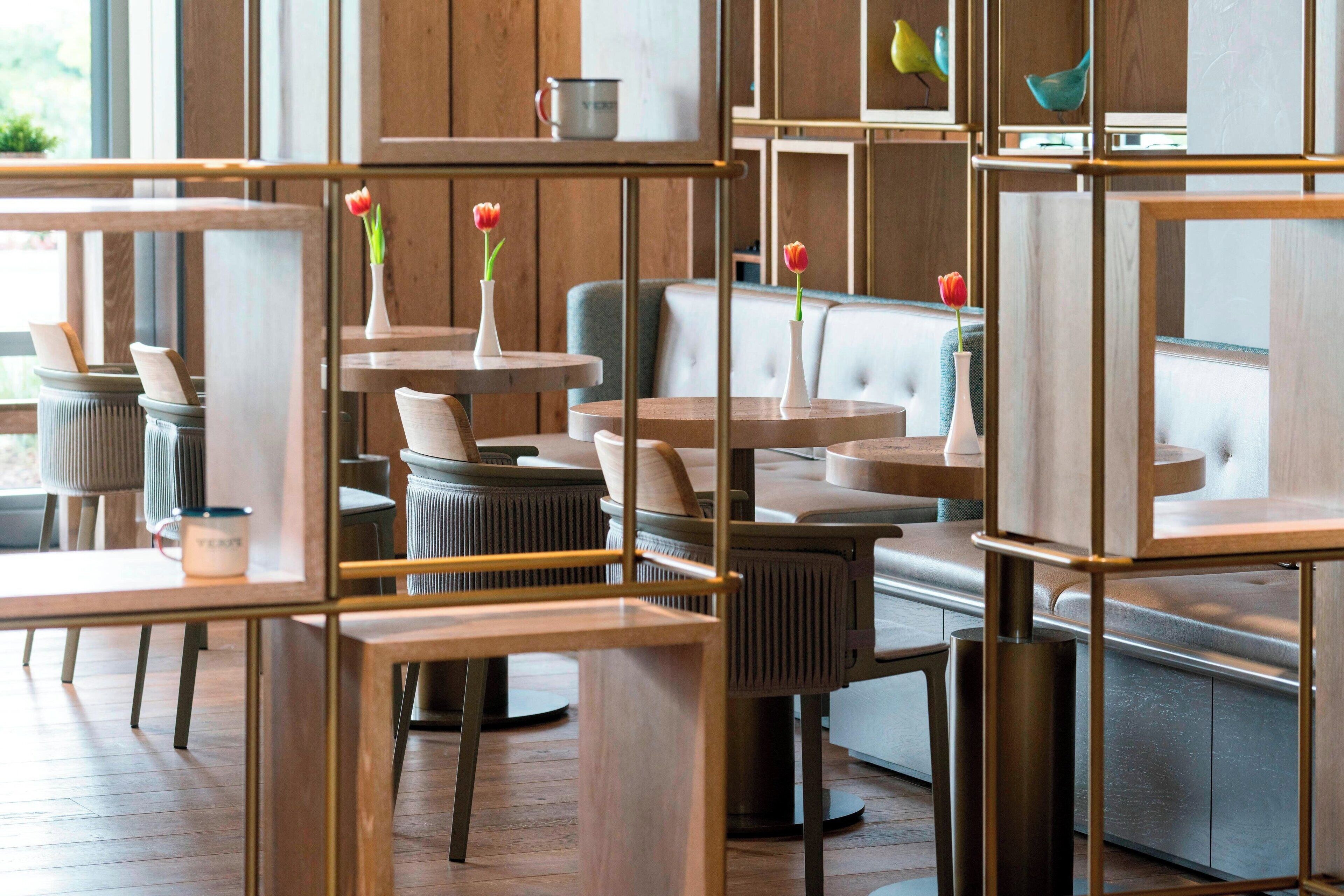 A modern interior with wooden furniture, cushioned seating, and decorative vases.