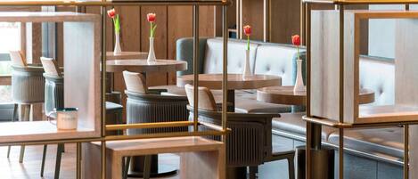A modern interior with wooden furniture, cushioned seating, and decorative vases.