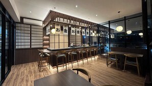 A restaurant interior with a bar area, wooden flooring, and a view of the cityscape. - PIA Hotel Bandung (Bandung)