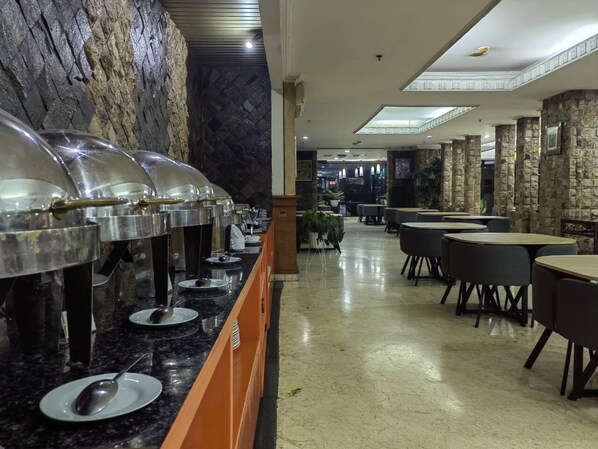 A buffet area with food dispensers, tables, and chairs. - PIA Hotel Bandung (Bandung)