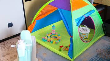 A small play tent with colorful sides and a toy castle inside.