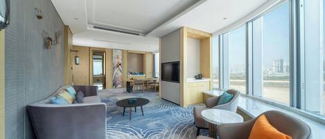 Ein modernes Hotelzimmer mit Wohnbereich, Essbereich und einer Küche.