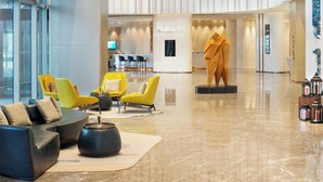 A modern lobby with a seating area, a reception desk, and a statue. - Le Meridien Xi'an Chanba (Xi'an)