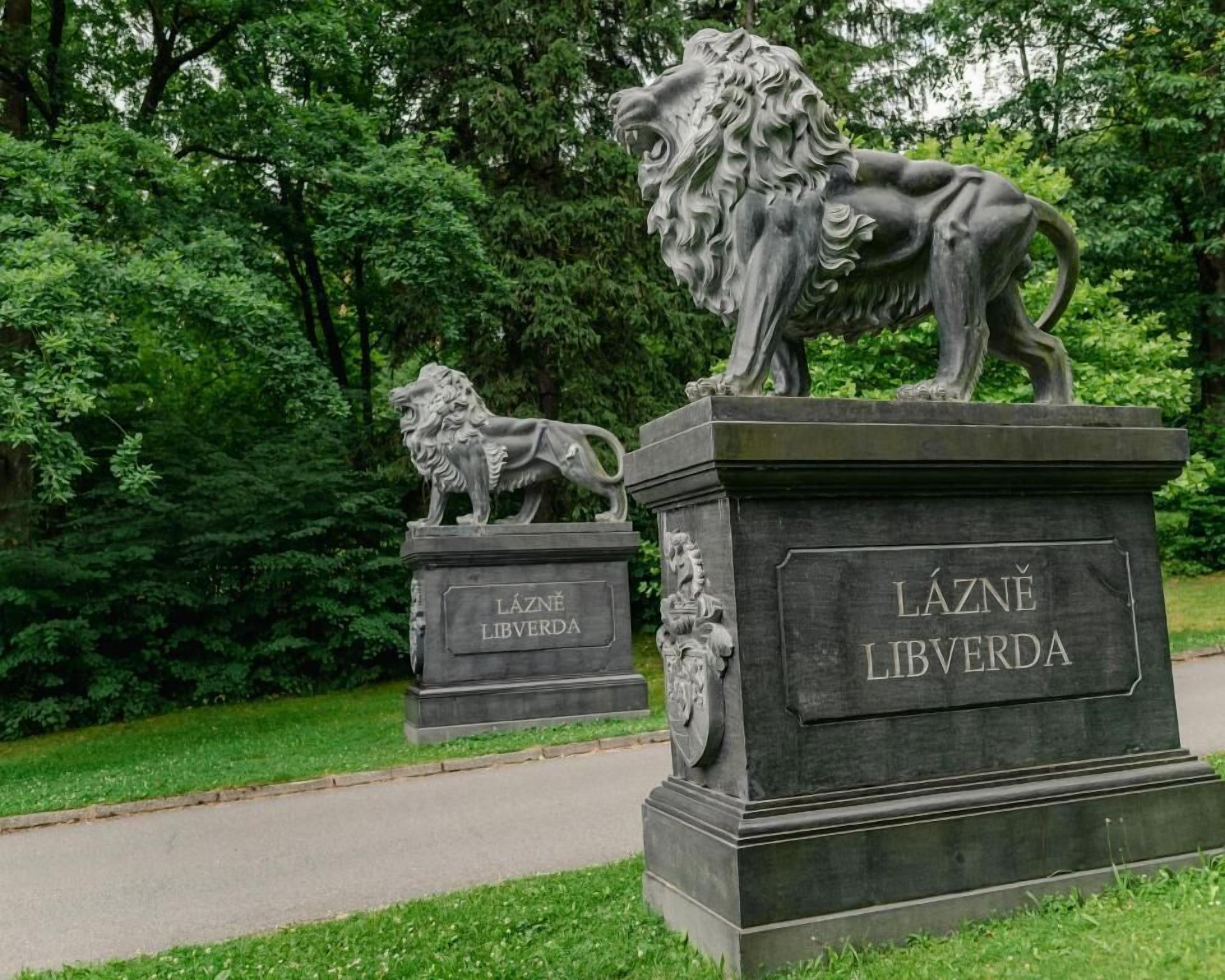 Two stone monuments with inscriptions, surrounded by greenery.