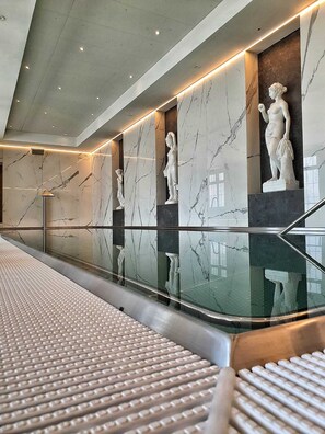 A modern interior with marble walls, a glass railing, and classical statues. - Spa Resort Libverda - Villa Friedland (Lázne Libverda)