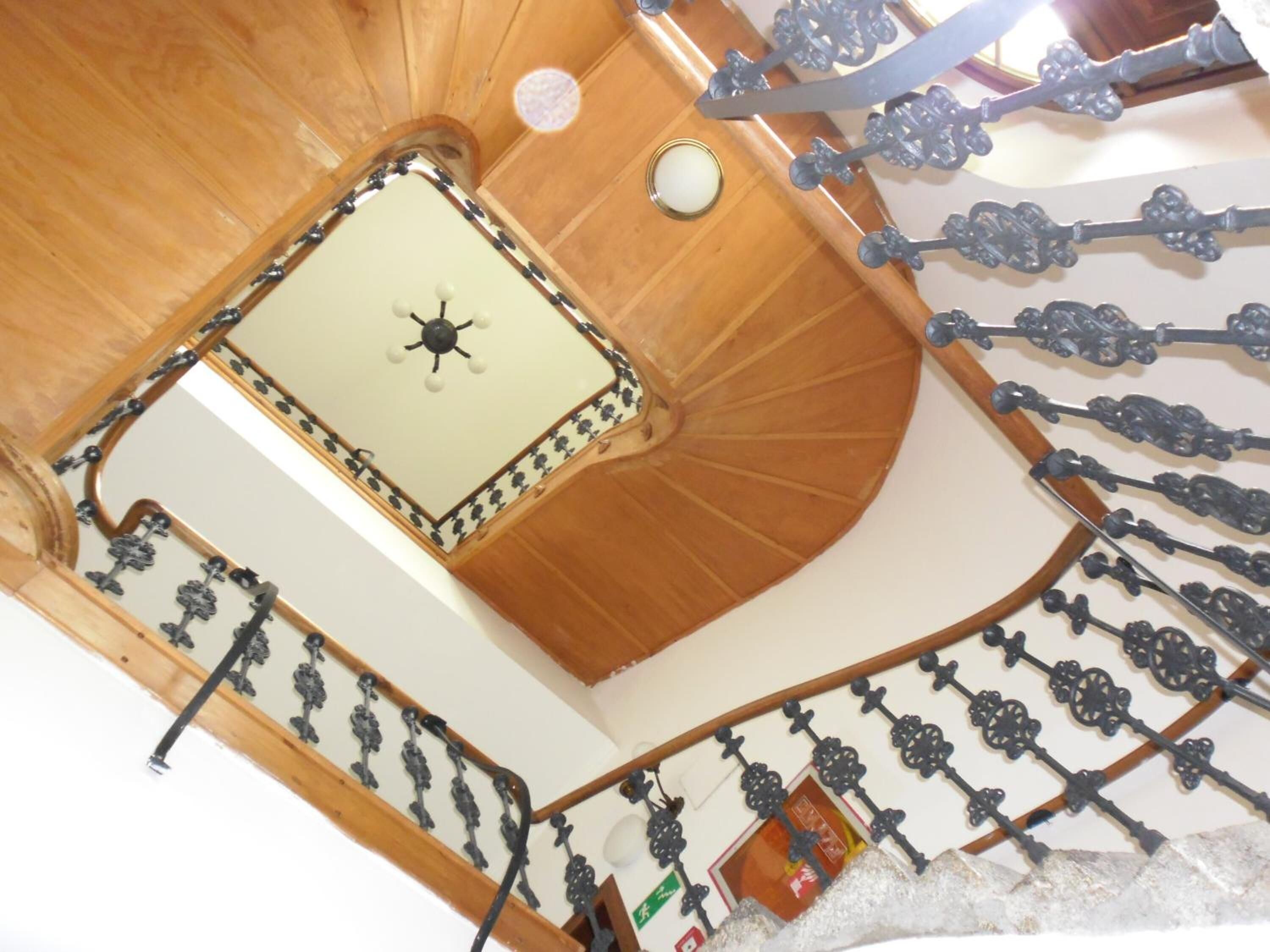 A spiral staircase with ornate metal railings and a wooden finish.
