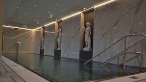 A swimming pool with marble walls and statues, a glass barrier, and a metal staircase. - Spa Resort Libverda - Villa Friedland (Lázne Libverda)