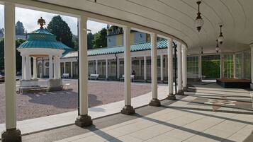 A covered outdoor area with a gazebo, benches, and a tiled floor.