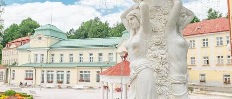 A classical statue with intricate carvings in a public square.