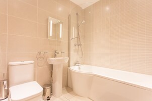 Un baño moderno con inodoro, lavamanos y bañera.